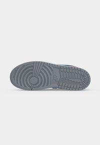 Γκρι λαστιχένια σόλα παπουτσιού Nike με κυκλικό και πλεγμένο σχέδιο πέλματος και το λογότυπο της Nike ανάγλυφο στο κέντρο.