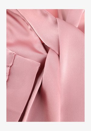 Zacht roze satijnen stof met een gladde textuur, dicht opgevouwen en gelaagd, met nadruk op glans en fijne weefseldetails.