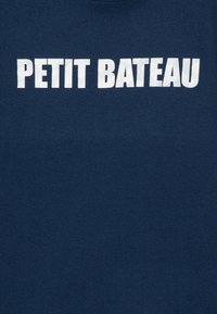 Námořnicko modré bavlněné tričko s velkým bílým textem "PETIT BATEAU" na hrudi, s jemnou a hladkou texturou.