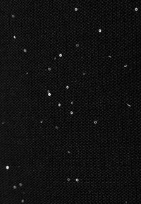 Black fabric featuring a textured surface with scattered white sequins, creating a subtle contrast and visual interest throughout.