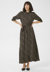Černé maxi šaty s krátkými nabíranými rukávy, zdobené květinovým vzorem v béžové barvě. S vázaným pasem a zapínáním na knoflíky. Elegantní splývavá látka.