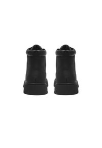 Black ankle boots with a smooth leather exterior, rounded toe, cushioned collar, and thick rubber sole. Minimalist design with no accents.