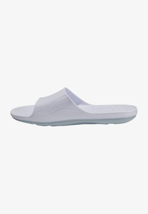 White slip-on sandal with a smooth, flexible material, featuring a wide strap over the foot and a textured sole for grip.