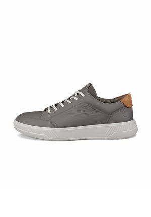 Grauer Sneaker aus Leder in niedriger Ausführung mit weißen Schnürsenkeln, weißer dicker Sohle und braunem Wildleder-Fersenlasche, von der Seite auf weißem Hintergrund gezeigt.