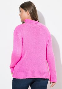 Pull en tricot fuchsia avec un col montant, un ourlet côtelé et des manches longues. La texture est épaisse, offrant une apparence chaleureuse.
