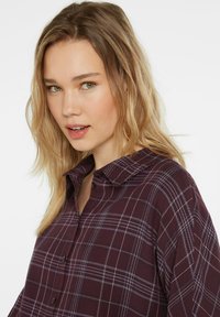 Plum plaid shirt featuring a button-down design, collared neck, and contrasting white lines in a lightweight fabric.