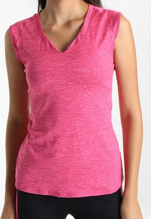 Woman wearing a sleeveless, pink V-neck athletic top with black pants, standing against a plain, light background.