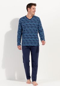 Camicetta a maniche lunghe blu navy con un motivo astratto blu, abbinata a pantaloni navy semplici. Tessuto morbido e vestibilità rilassata, adatta per un abbigliamento casual.