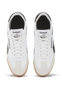 White sneakers with a suede toe, black accents, and rubber gum sole. Features a lace-up design and Reebok branding on the tongue.