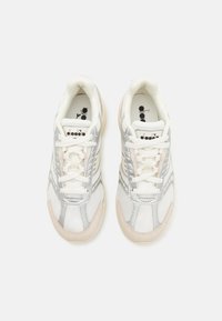 Sneaker in mesh bianco e sintetico con accenti grigio chiaro, lacci piatti, suole imbottite e un logo sulla linguetta.