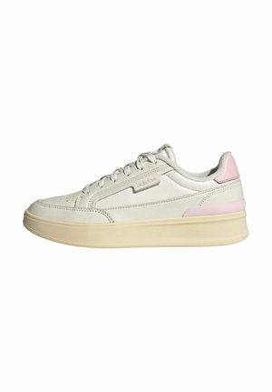 Scarpa sportiva grigia chiara con tomaia in pelle liscia, dettagli testurizzati in rosa e una suola in gomma beige spessa. Caratterizzata da lacci piatti e forature.