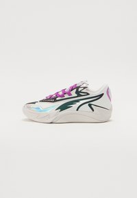 Sneaker med en hvid meshuoverdel, grønne accenter, iridescerende detaljer og lilla snørebånd. Har en tekstureret sål og buede designelementer.