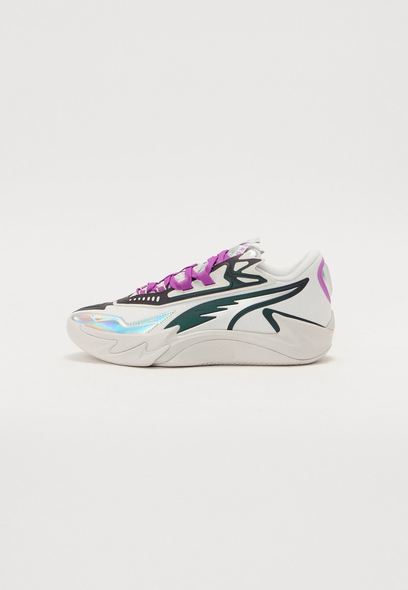 Sneaker med en hvid meshuoverdel, grønne accenter, iridescerende detaljer og lilla snørebånd. Har en tekstureret sål og buede designelementer.