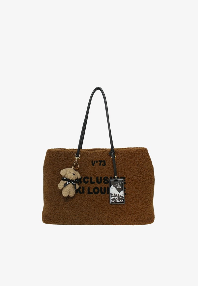 Borsa a tote marrone con manici neri, testo nero "Exclusive Ski Lounge", un portachiavi a forma di orsetto e un tag per il pass di sci.