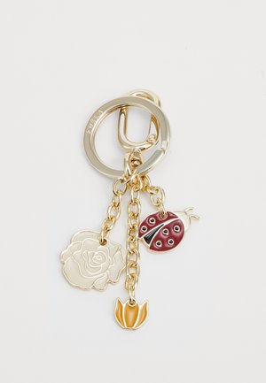 Chaveiro em tom de dourado com três pendentes: uma rosa creme, uma joaninha marrom com manchas pretas e um tulipa laranja, todos pendurados em correntes delicadas.