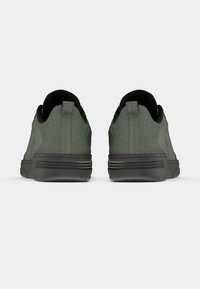 Green athletic shoes with a smooth texture, rounded shape, and black accents. Features a reinforced heel and flexible sole design.