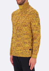 Maglione giallo lavorato a maglia con colletto alto, caratterizzato da un motivo a rombi testurizzato e polsini a costine. Etichetta visibile sul lato inferiore.