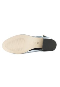 Schwarzer Knöchelstiefel mit glattem Obermaterial, goldenen Hardware-Details und einer strukturierten Gummisohle. Ausgestattet mit einer weichen Innensohle und elegantem Design.