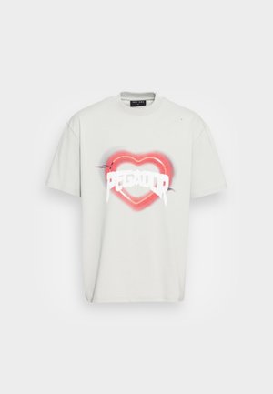 Vaaleanharmaa ylijättö-t-paita, jossa on keskellä punainen sydän ja valkoista tippuvaa tekstiä "PEGA", pyöreä pääntie ja lyhyet hihat.