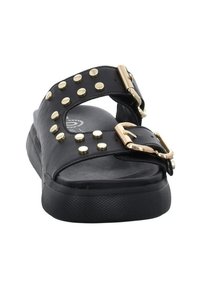 Sandale noire avec larges brides ornées de clous dorés et une grande boucle dorée. La semelle est texturée et légèrement surélevée pour le confort.