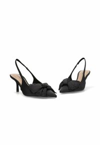 Tacones negros de tiras con un diseño de punta afilada, tela texturizada y un lazo anudado en la parte delantera. Presenta un tacón delgado.