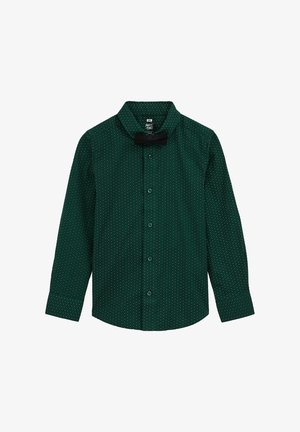 Zöld, hosszú ujjú ing fehér pöttyökkel, gombos elülső résszel és hegyes gallérral. A nyakban egy fekete csokornyakkendő található.