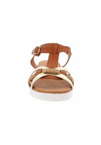 Sandalo in pelle marrone con accento di fibra naturale intrecciata e cinturini dorati, dotato di suola in gomma bianca e fibbia regolabile alla caviglia.