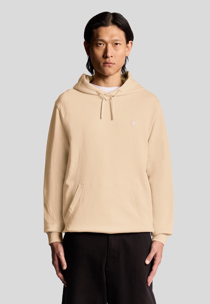 Beige Kapuzenpullover aus weichem Stoff, mit einer Kängurutasche, verstellbarem Kordelzug mit Kapuze und einem kleinen gestickten Logo auf der Brust.