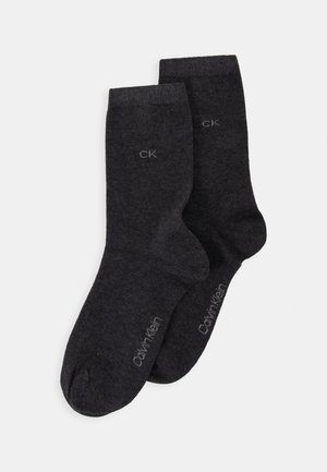 Two pairs of dark gray socks made from a soft fabric, featuring a ribbed design and "CK" logo printed in light gray near the top.