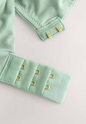 Țesătură verde mentă cu textură fină, decorată cu accente metalice aurii. Designul include mai multe închideri cu cârlig și ochi.