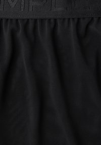 Tissu en maille noir avec une ceinture texturée présentant des lettres en relief. Le matériau est léger avec un motif de tissage ouvert et respirant.