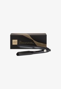 GHD Max, lisseur professionnel à plaques larges, avec finition noire mate, présenté ouvert devant un emballage de marque noir et doré.