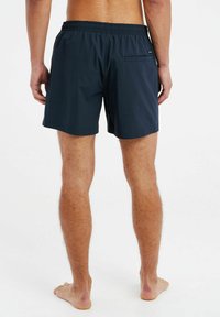 Marineblauwe zwembroek met een elastische tailleband, zijzakken en één achterzak. Gemaakt van lichtgewicht, sneldrogend materiaal.