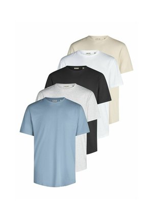 Man die een effen lichtblauw T-shirt met korte mouwen en blauwe spijkerbroek draagt, staand tegen een witte achtergrond.