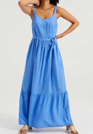 Maxikleid aus hellblauem Stoff mit einem gepunkteten Muster, das ein tailliertes Oberteil, verstellbare Träger und einen gestuften Rüschensaum aufweist.