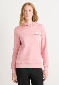 Sudadera con capucha rosa de textura suave, que presenta un pequeño logo blanco de GANT y líneas de acento rojas en el pecho. Mangas largas y ribete acanalado.