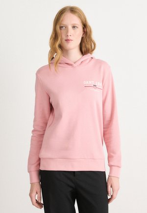 Felpa con cappuccio rosa dal tessuto morbido, con un piccolo logo GANT bianco e linee rosse a contrasto sul petto. Maniche lunghe e orlo a coste.