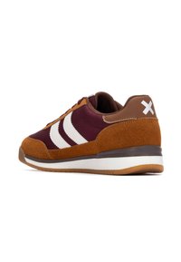 Zapatillas marrones y burdeos con rayas blancas, materiales de ante y malla, puntera redondeada y suela de goma texturizada. Detalle de logo notable en el talón.