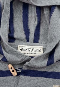 Grå og marineblå stribet børnesweater med træknaplukning og en label med teksten "Band of Rascals." Blød strikket tekstur.