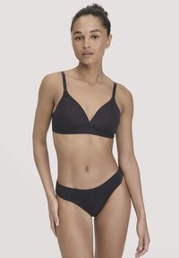 Zwarte naadloze bralette met draadloze cups en verstelbare bandjes, gecombineerd met bijpassende bikinislips met lage taille, gemaakt van zachte, rekbare stof.