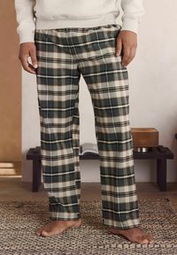 Pantaloni de lounge în carouri, în tonuri de verde, bej și maro. Realizați dintr-un material moale, cu o croială confortabilă și un elastic la talie.