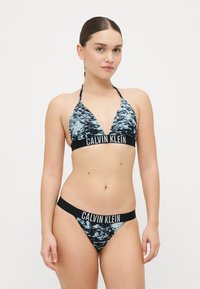 Juoda ir mėlyna raštuota bikini komplektas su trikampiu viršumi ir žemu liemeniu, kuriame yra prekės ženklo elastinga juosta. Lygi, tampri medžiaga.