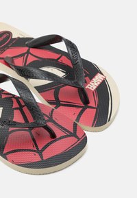 Chanclas negras con un diseño de Spider-Man en rojo y negro, suela texturizada y base de goma color marrón.