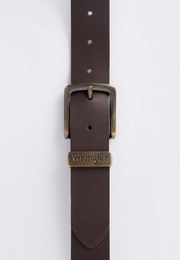 Brauner Ledergürtel mit antiker Messingschnalle und einer Metallöse mit eingraviertem Markennamen Wrangler.