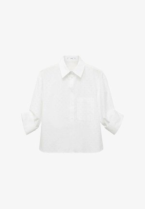 Chemise blanche à manches courtes avec col pointu, présentant un motif discret à pois et une poche poitrine. Tissu léger, coupe oversize.