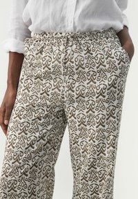 Gepatternde broek in wit en bruin. Elastische tailleband, zijzakken, met een draaimotief van bladeren. Lichtgewicht stof met een gestructureerde afwerking.
