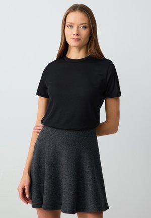 Zwarte geribbelde T-shirt met korte mouwen, gecombineerd met een uitlopende roestgrijze rok van zacht materiaal. Beide kledingstukken hebben een eenvoudig, klassiek ontwerp.