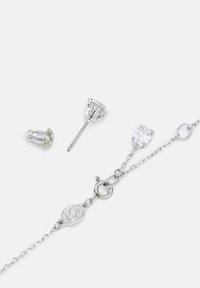 Sølv smykkesæt med et kædearmbånd med lås og klare krystalstudøreringe i en prongindstilling.