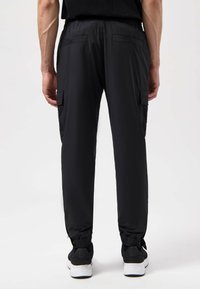 Zwarte cargobroek met elastische boorden, een trekkoord in de taille en meerdere zakken, gemaakt van een lichtgewicht, gladde stof.