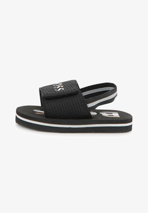 Melnas sandales ar spilventiņotu siksnu, kam ir teksturēta virsma, baltas un gaiši zilas krāsas starplika un logo priekšpusē.